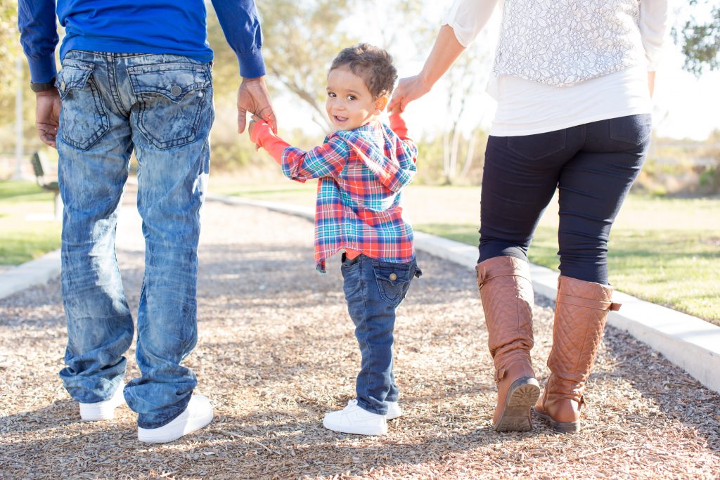 Family holding hands walking in a park 